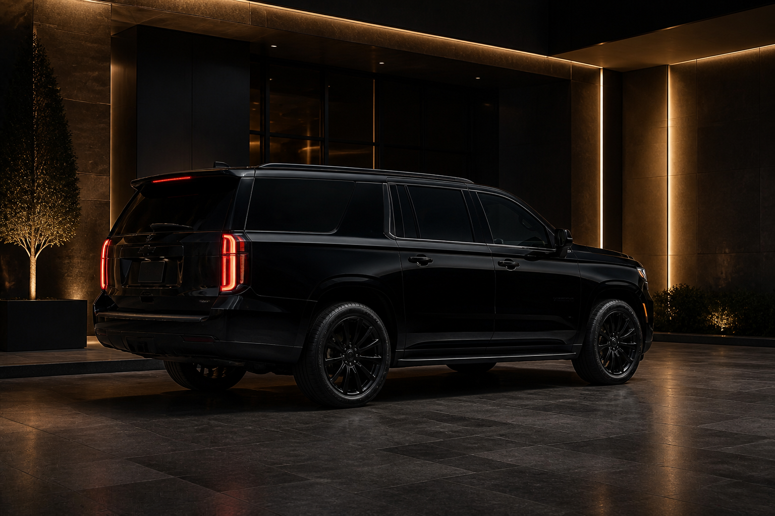 Black luxury SUV parked at a private arrival entrance at night